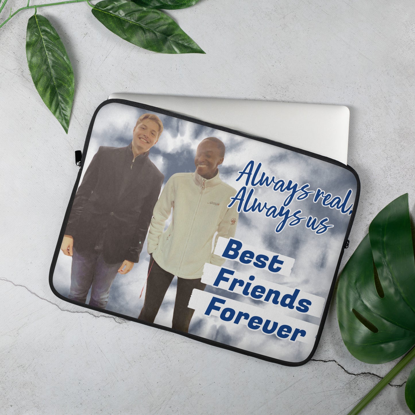 Laptop sleeve with two people standing together and text 'Always real, Always us. Best Friends Forever' on a cloudy sky background.