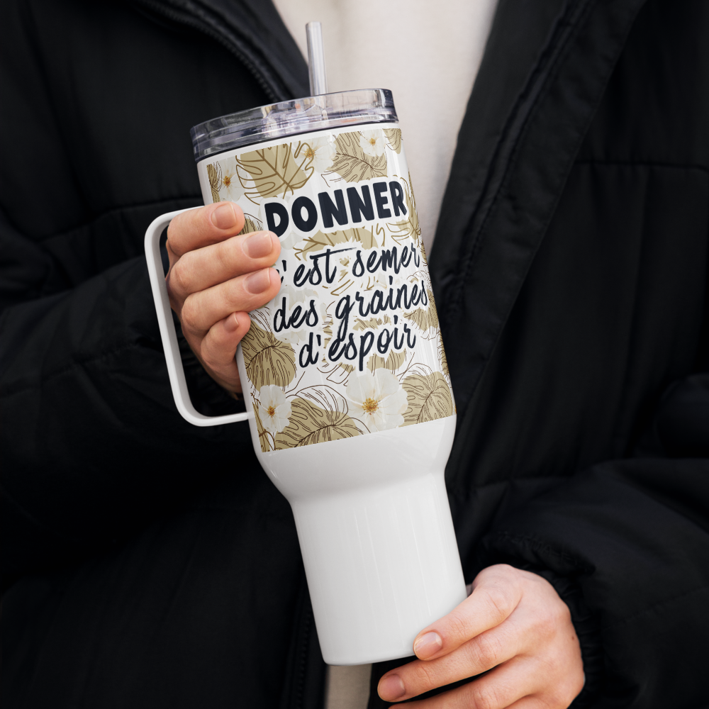 Person holding a white tumbler with floral design and text
